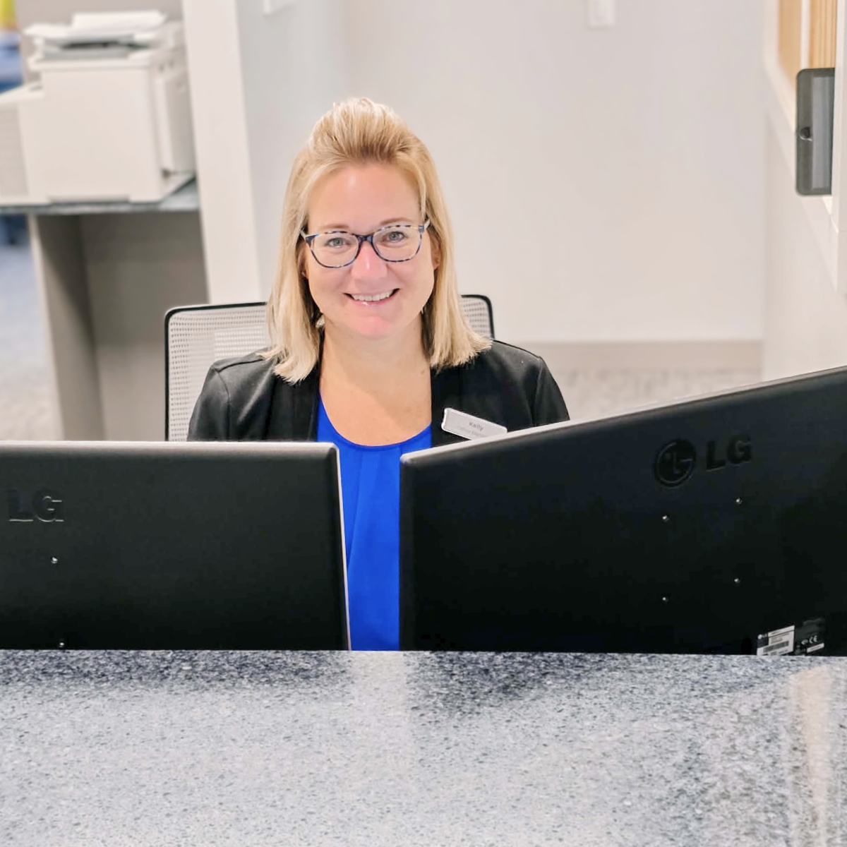 Front desk team member smiling at MI Smiles Dental Group