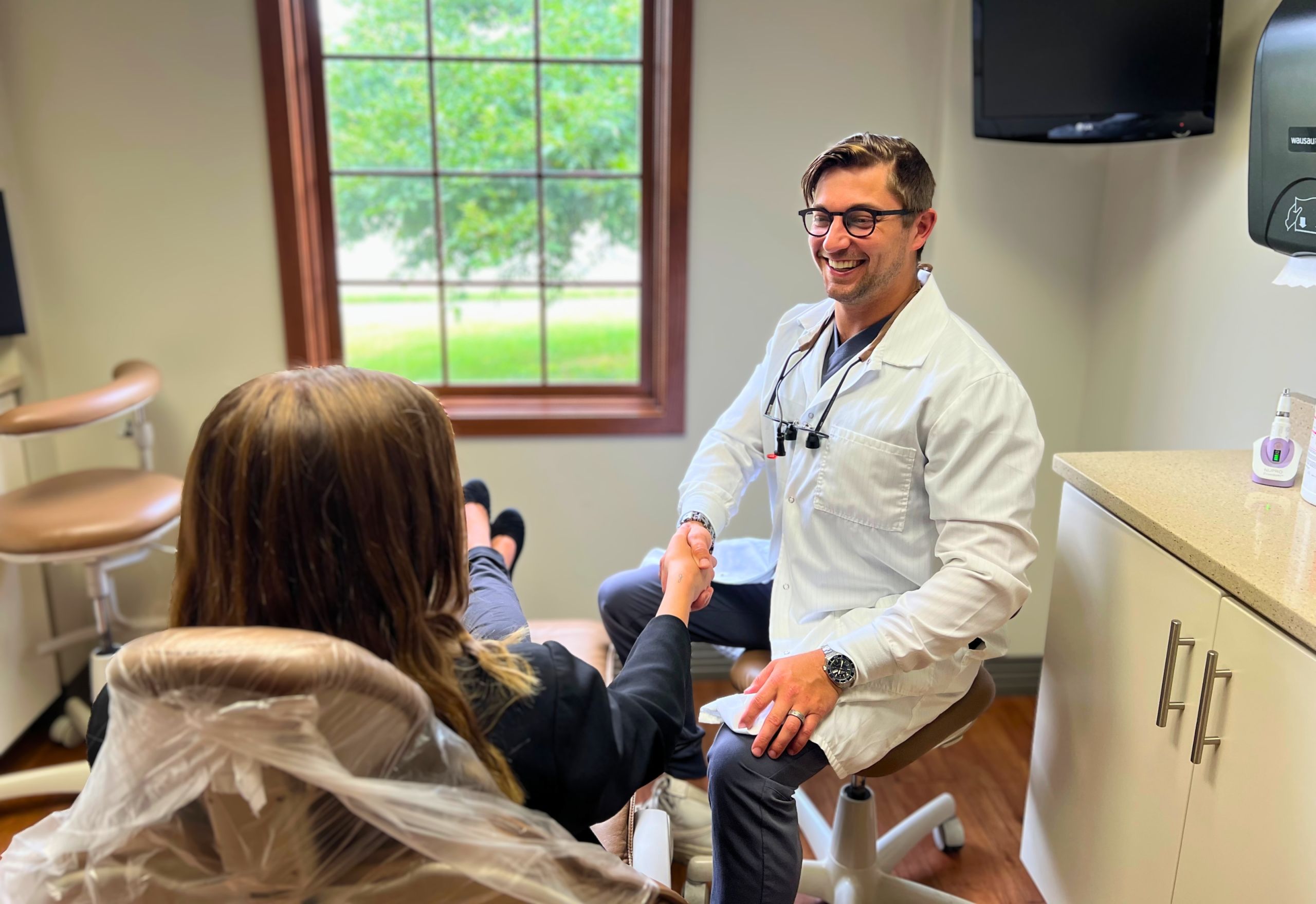 MI Smiles Dental Group doctor meeting with patient in treatment room