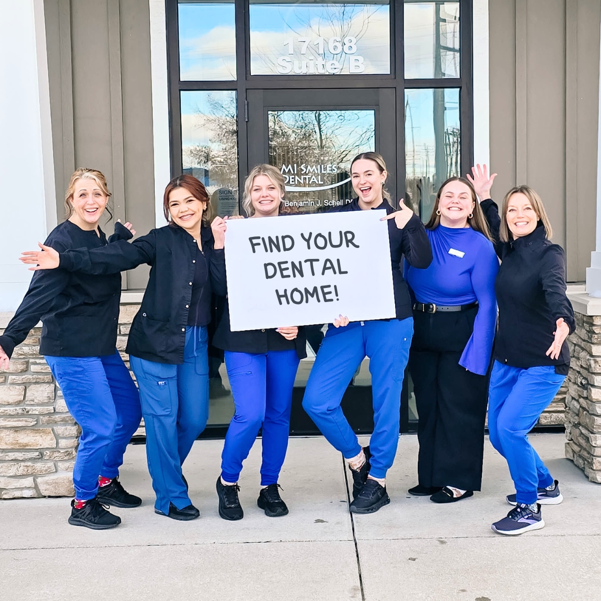 MI Smiles Dental Group team holding a Find Your Dental Home sign