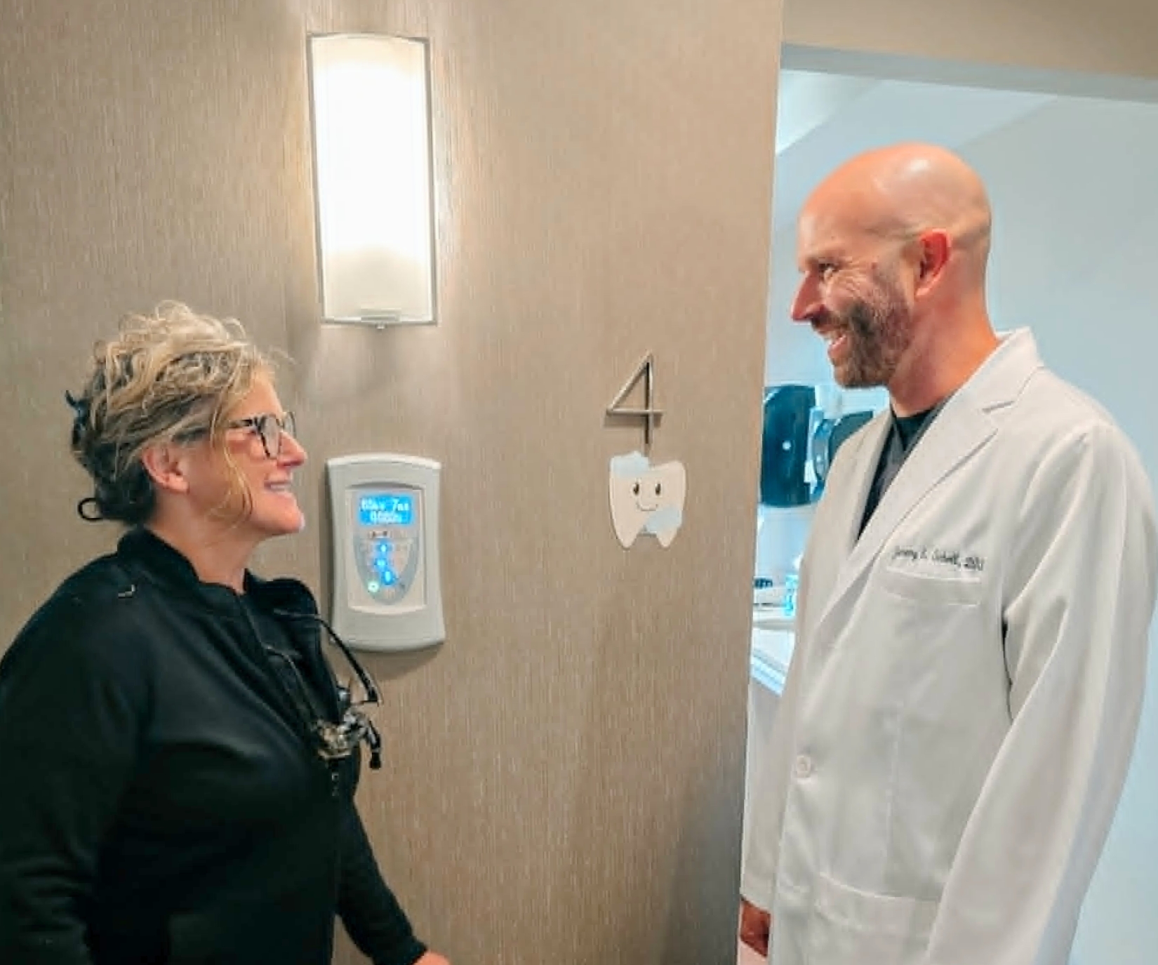 A dental hygienist and dentist having a friendly conversation