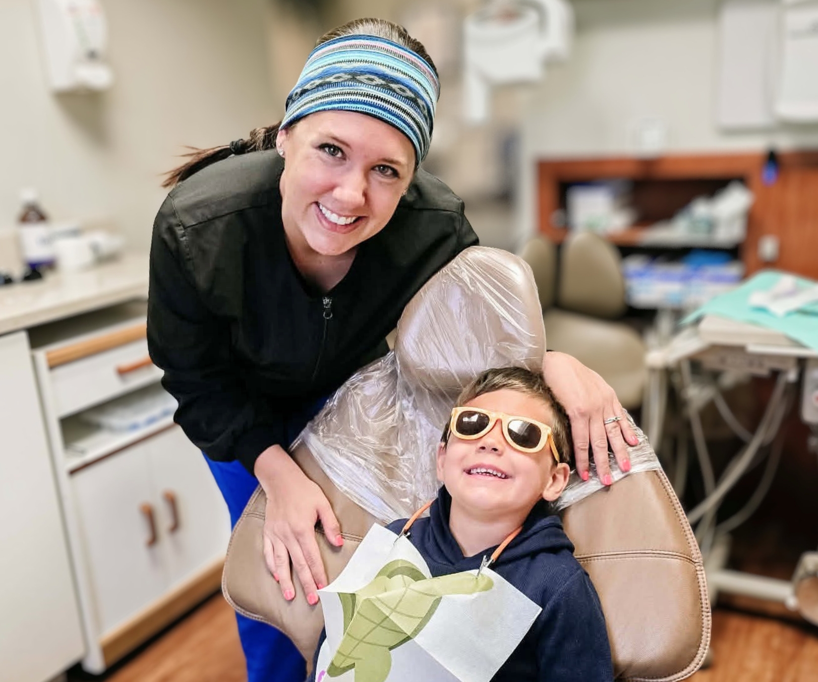 A dental hygienist smiling with a young patient