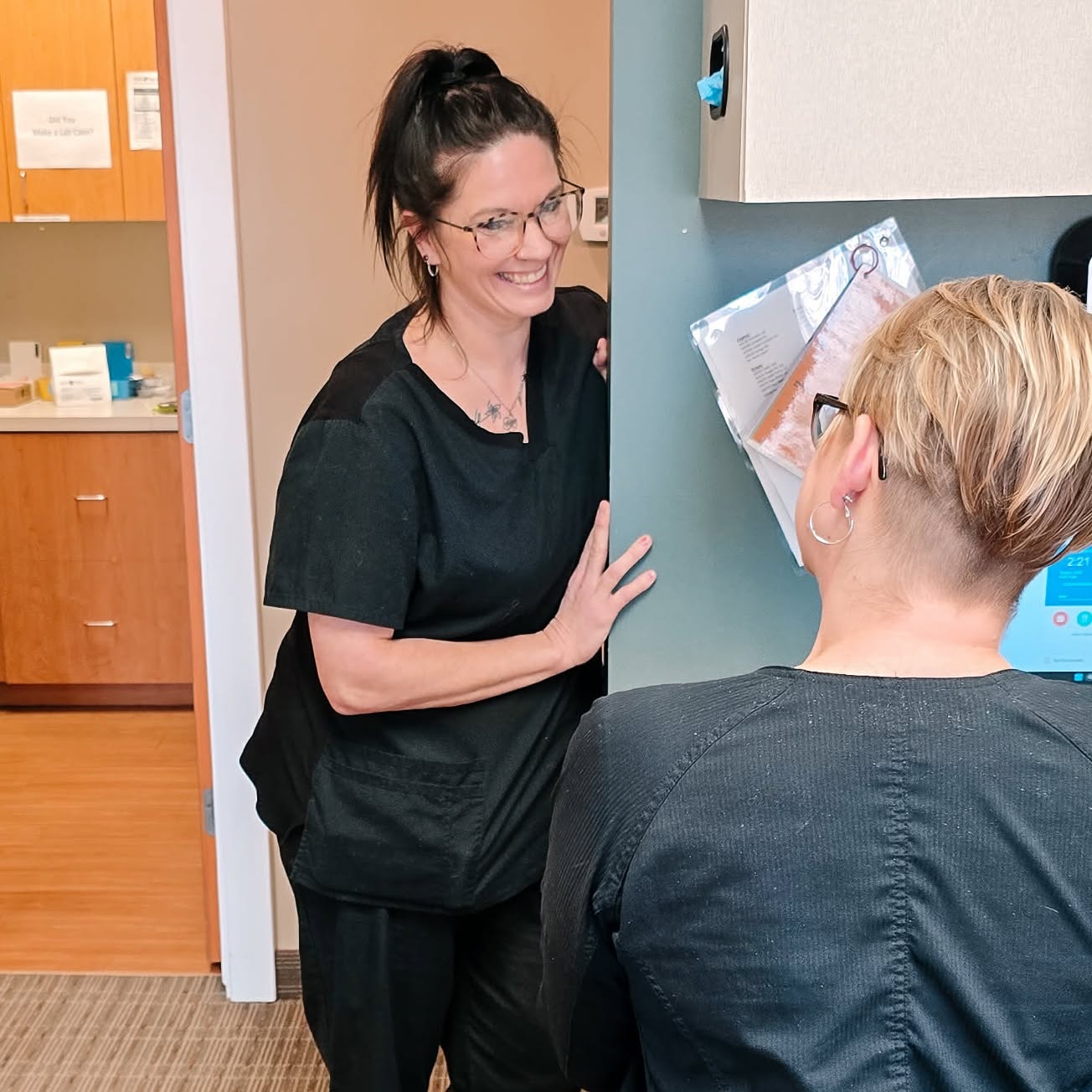 An MI Smiles Dental hygienist speaking with a colleague