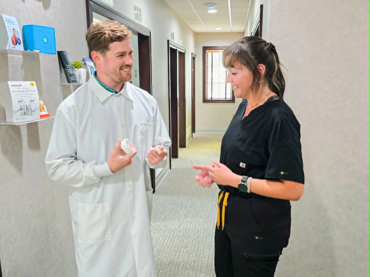 A dental hygienist and dentist discussing patient care at MI Smiles Dental